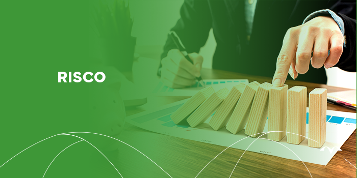 Imagem que mostra um empresário segurando uma caneta e escrevendo em um papel sobre a mesa. A frente de toda a cena, temos peças de dominó enfileiradas em sequência e caindo uma sobre a outra.